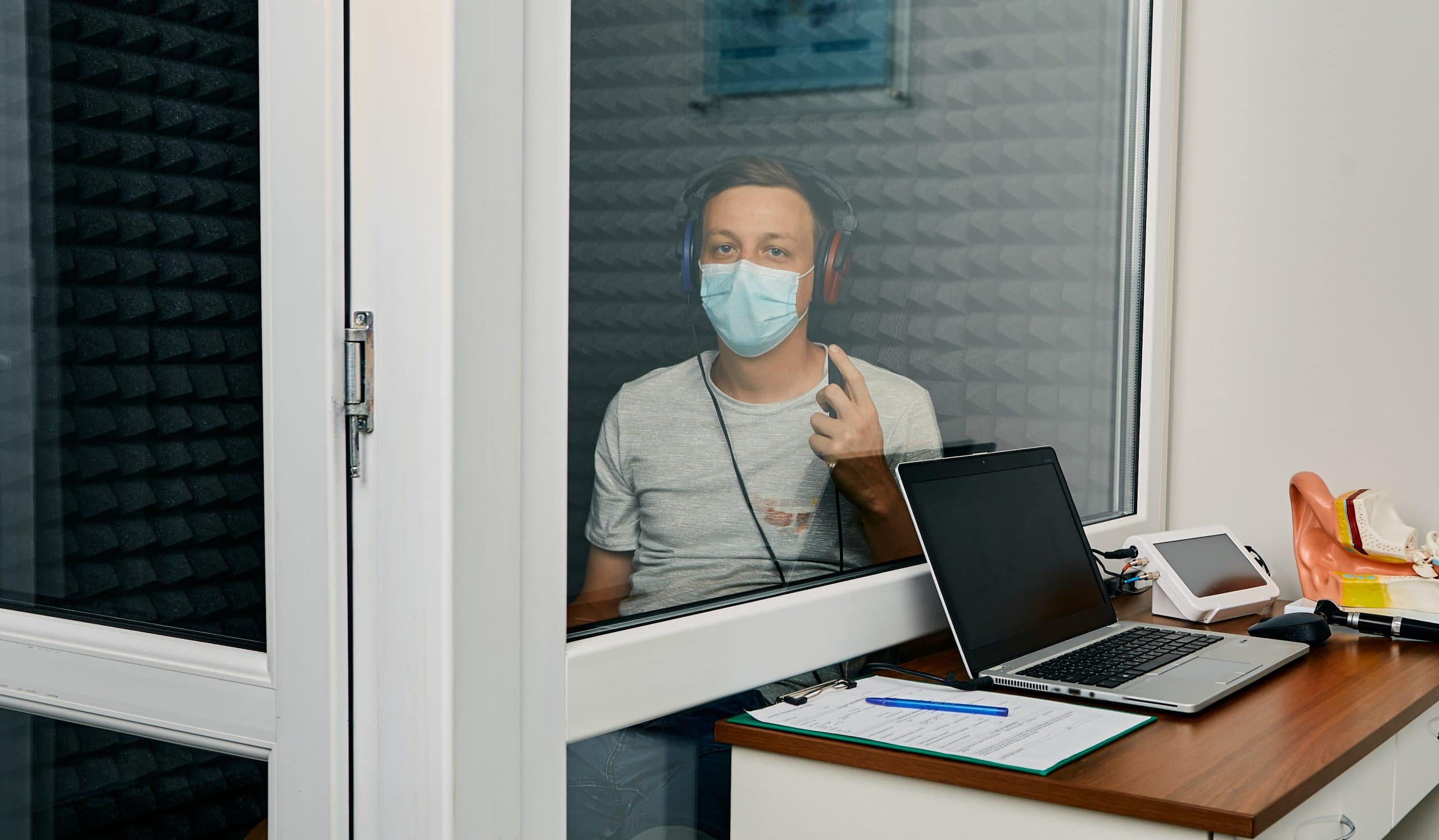 Adult man getting a hearing test at audiology center. Audiometry.