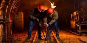 Workers performing muscle straining movements in a mine