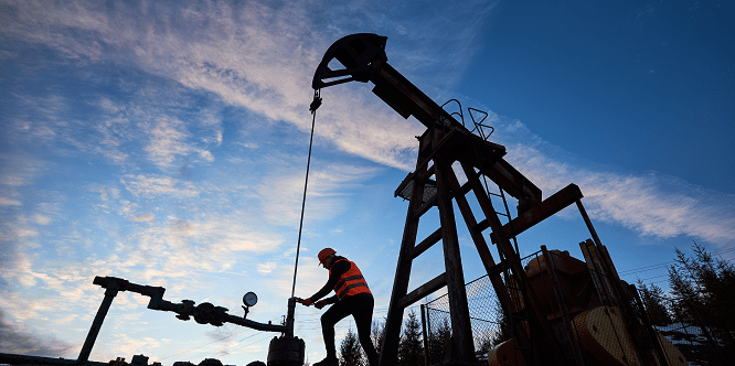 Oil worker using oil pump rocker-machine in oil field